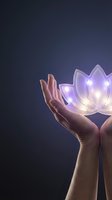 Hands holding glowing lotus flower with soft purple light against dark background, representing spirituality, healing, wellness, and mindfulness practices.