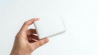 Man's hand holding open blank white box on white background, product packaging mockup for retail display and branding purposes.