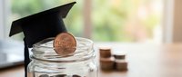 Graduation cap on glass jar with future coin symbolizing education savings and financial planning for college tuition and academic investment goals.