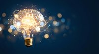 Glowing light bulb with brain inside surrounded by sparkling particles and bokeh lights on dark blue background representing innovation and creative thinking.