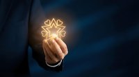 Businessman holding glowing lightbulb with leaf design symbolizing eco-friendly innovation, renewable energy, and sustainable business solutions for corporate growth.