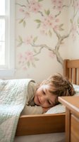 Peaceful young child sleeping in wooden bed with floral wallpaper background in cozy bedroom interior for family lifestyle and parenting concepts.