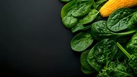 Fresh green spinach leaves and corn on dark background for healthy cooking and nutrition concepts.