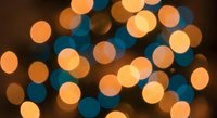 Abstract bokeh lights background with warm orange and cool blue circular highlights creating dreamy atmosphere for holiday decorations and festive designs.