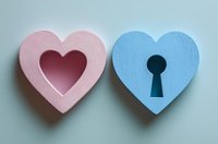 Pink heart with cutout and blue heart with keyhole shape on light background, symbolizing love connection, romance and relationship concept.