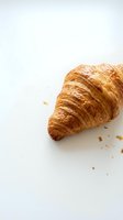 Golden buttery croissant with flaky layers and crumbs on clean white background for bakery menu design and food photography projects.