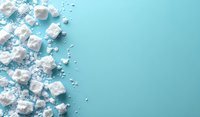 White scattered sugar cubes and granulated sugar creating diagonal border on turquoise background with copy space, top view flat lay composition.