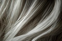 Close-up of blonde and brown hair strands showing highlights and lowlights texture with natural wave pattern for beauty and salon marketing.