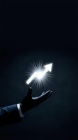 Businessman hand holding glowing upward arrow symbol against dark background, representing growth, success, and positive business direction for corporate concepts.