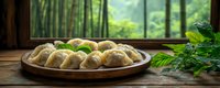 Homemade dumplings on rustic wooden plate with fresh herbs near window overlooking lush bamboo forest, moody atmospheric food photography.