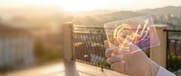 Hand holding transparent tablet with glowing growth chart and arrow at sunset, symbolizing financial success, digital innovation, and future technology.
