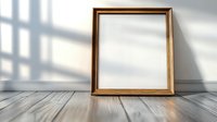 Empty wooden picture frame leaning against white wall on rustic wooden floor with natural window light and shadows creating minimalist composition.