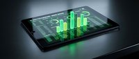 Modern tablet displaying holographic financial data visualization with green glowing charts and graphs for business analytics and market research presentations.