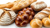 Fresh artisan bread assortment with baguettes, sourdough loaves, braided challah and dinner rolls isolated on white background for bakery marketing.