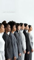 Group of diverse women in business attire standing in profile against white background, representing unity, inclusion, and professional teamwork across different ethnicities and backgrounds.