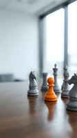 Orange chess pawn standing out among gray pieces on wooden board near office window, symbolizing leadership and strategic thinking in business.