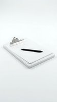 Clipboard with blank document and black pen on white surface, ready for writing, signing, or business tasks.
