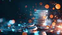 Stack of silver coins with glowing orange bokeh lights and sparkles on dark background, financial concept showing wealth, savings and investment growth.