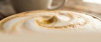 Creamy cappuccino with latte art foam design and cinnamon powder dusting, served in ceramic cup for café and beverage concepts.