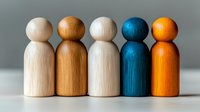 Wooden peg dolls in different colors standing in row showing diversity and inclusion concept, natural and painted figures on neutral background.