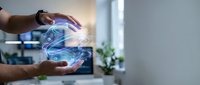 Hands holding glowing digital hologram with blue light waves and data streams, representing technology innovation, artificial intelligence, and future digital transformation in modern office environment.