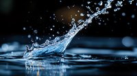 Dynamic water splash with droplets frozen in motion against dark background, creating dramatic liquid sculpture effect with crystal clear details and blue tones.