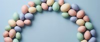Colorful pastel Easter eggs arranged in decorative circle on light blue background for spring holiday celebration and festive seasonal design projects.