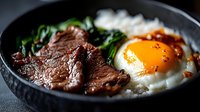 Savory Korean bibimbap bowl with marinated beef, sunny side up egg, steamed rice, and fresh spinach served in traditional black stone bowl.