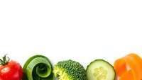 Fresh organic vegetables arranged on white background with copy space for healthy eating and nutrition concepts.