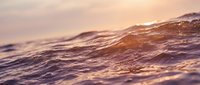 Ocean waves at sunset with golden light reflecting on water surface creating peaceful seascape for relaxation and meditation backgrounds.