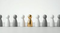 Golden figure stands out among white and gray wooden pawns representing leadership, uniqueness and business success concepts.