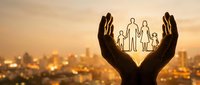 Protective hands cupping family silhouette against golden sunset city backdrop symbolizing care, security, insurance and family protection concept.