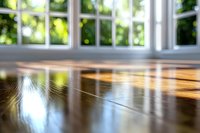 Sunlight streaming through windows creates golden reflections on polished hardwood flooring, casting warm shadows and bokeh effect in bright morning interior.