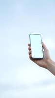 Hand holding smartphone with blank white screen against light background, mockup for app or website display presentation.