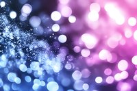 Abstract bokeh lights background with sparkling particles in blue and pink gradient colors for festive celebrations and magical atmosphere.