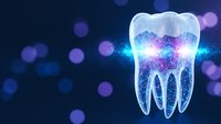 Glowing translucent tooth with cosmic energy and light effects on dark blue background with bokeh lights for dental care and oral health concepts.