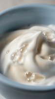 Creamy facial cleanser with bubbles in blue bowl for skincare routine and beauty treatment applications.