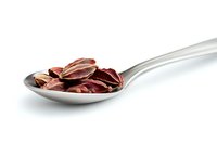 Dried red cardamom pods arranged on stainless steel spoon against white background, macro food photography showing aromatic spice detail and texture.