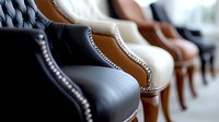 Row of luxury leather armchairs in different colors from black to brown and beige, showing elegant stitching details and classic furniture craftsmanship.
