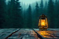 Glowing oil lamp on rustic wooden surface against misty pine forest background creates moody atmospheric scene with warm light contrasting dark evening landscape.