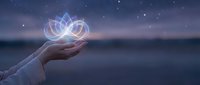 Hand holding glowing infinity symbol with geometric patterns against starry night sky background for spiritual and technology concepts.