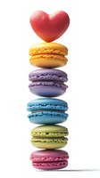 Colorful French macarons stacked vertically with red heart on top against white background, isolated dessert composition for Valentine's Day and confectionery design.