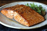 Grilled salmon fillet with herbs on ceramic plate, cooked fish dinner, healthy protein meal, restaurant quality seafood dish for culinary and food photography.
