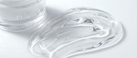 Clear gel or serum sample spread on white surface with container, suitable for cosmetics, skincare, beauty product packaging, and laboratory presentations.