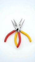 Two needle nose pliers with red and yellow handles crossed on white background isolated for crafting and electrical work projects.