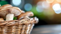 Fresh mushrooms in woven basket against blurred bokeh background, close-up view highlighting natural texture and warm tones for food and culinary concepts.