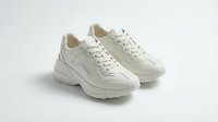Pair of white chunky sneakers with thick sole and lace-up design, isolated on light background, for fashion and footwear retail use.