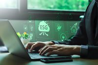 Businessman hands typing on laptop with ESG environmental social governance holographic icons floating above keyboard in modern office workspace.