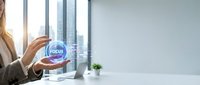 Woman in business attire holding glowing focus orb with cityscape visible through office windows, representing concentration and professional goals.
