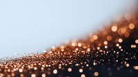 Copper and gold glitter particles scattered on dark surface with bokeh effect creating luxurious festive background for holiday designs.